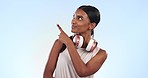 Pointing, fitness and young woman in a studio by mockup for marketing, promotion or advertising. Sports, athlete and Indian female model with presentation hand gesture isolated by white background.