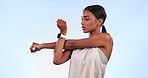 Indian woman, stretching arms and athlete at gym with fitness, workout and muscle on blue background. Warm up, training and exercise in studio, sports and health with wellness, active and power