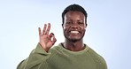 Happy, face and man in studio with perfect hands, okay or gesture of support on blue background. Smile, portrait and African male model with ok finger emoji for thank you, good job or goal success