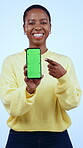 Black woman, face with smartphone and green screen, ads on website or app advertising on blue background. Portrait, social media promo and point at tech with communication, news and info in studio