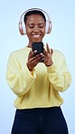 Laughing black woman, headphones and phone to search music, social media or internet browsing on studio blue background. Funny, technology and listening to radio, podcast and streaming app selection