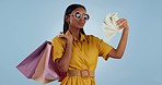 Rich woman, money fan and shopping bags for payment, buying or purchase against a studio background. Portrait of female person or shopper with cash in financial freedom, discount sale or promo deal