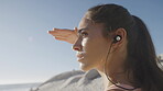 Fitness, music and view with a sports woman at the beach for a workout during summer with mockup. Training, exercise and blue sky with a young female athlete streaming audio while running in nature