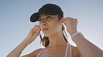 Woman, face or music earphones in fitness workout, training or exercise on blue sky background or Portugal nature. Portrait, runner or sports athlete listening to motivation radio or wellness podcast