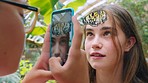 Girl friends, butterfly and phone photo in garden, park or nature on adventure, learning or social media. Teenager, smartphone or digital picture for insect face by trees, forest or excited in summer