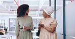 Business team, talking and walking together for communication, gossip or happy conversation while working at a coworking office. Black women with a phone and paperwork while sharing ideas and advice
