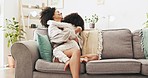 Love, embracing and mother with her child while relaxing on a sofa in the living room of their home. Happiness, bonding and young mom hugging and kissing her girl kid with care in their family house.