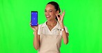 Phone, green screen and young woman in studio for marketing, advertising and promotion. Technology, tracking markers and portrait of female model with mobile and ok gesture by a chroma key background