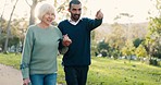 Walk, crutch and caregiver with his senior patient in a park for support, help or balance in nature. Medical, wellness and young man doing a cardio exercise with an elderly woman in an outdoor garden