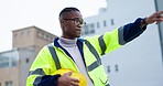 Black man, architect and hard hat in city for construction management, inspection or maintenance. African male contractor or engineer with safety helmet pointing on site for architecture or building