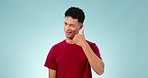 Face, man and wink to call me in studio for contact, communication and isolated on blue background. Portrait, happy model and flirting with calling sign, phone gesture and hand emoji for connection 