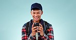 Happy, connection and man with a smartphone, typing and social media on a blue studio background. Person, happy guy and model with a cellphone, funny and meme with post, digital app and mobile user