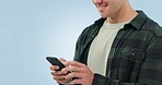Closeup, hands and man with a cellphone, connection and social media on a blue studio background. Person, guy and model with a smartphone, sms and digital app with chatting and email notification