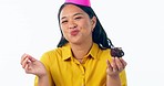 Face, birthday and woman with cupcake, dance and sweet treats on a white studio background. Portrait, person and happy model with a party hat, dessert and celebration with joy, event and excited