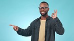 Pointing, options and face of black man in studio with mockup space for choice or decision. Choose, select and portrait of young African male model with show hand gesture isolated by blue background.