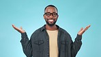 Scale, smile and face of black man in a studio with choose, decision or balance expression. Happy, mockup space and portrait of young African male model with comparison gesture by blue background.