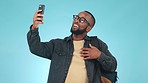 College, phone and a black man on a video call with a blue background for education communication. Happy, talking and an African student live streaming on a mobile app for university blog