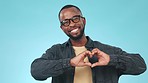 Heart, hands and black man with smile in studio for support, thank you gesture or love on blue background. Kindness, person and happiness with emoji, frame and pointing you for care and motivation
