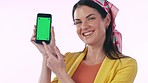 Happy woman, phone and pointing to green screen in advertising or marketing against a studio background. Portrait of female person smile, OK emoji or showing mobile smartphone app, display or mockup