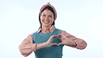 Happy woman, heart hands and pointing for love, support or trust in care against a studio background. Portrait of female person smile showing like emoji, shape or romantic gesture on mockup space