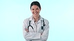 Happy studio doctor, arms crossed and woman confident in medical career, job experience or cardiology work. Happiness, healthcare portrait and medicine expert, nurse or surgeon on blue background