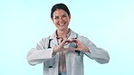 Face, woman or doctor with heart hands to you in studio for love icon, kindness and trust on blue background. Portrait of happy medical worker with emoji for healthcare, support or help in cardiology