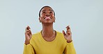 Fingers crossed, woman and hope for success in studio, waiting for luck and feedback of results on white background. African model, emoji sign and praying to wish for bonus, lottery prize and winning