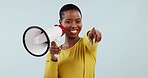 Happy black woman, megaphone and pointing to you in winning, prize or sale against a studio background. Portrait of African female person smile with bullhorn or loudspeaker for choice or selection