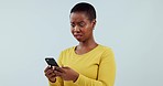 Shocked, black woman and smartphone with reaction, app and typing on a blue studio background. African person, girl and model with a cellphone, mistake and announcement with surprise and blog post