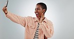 Happy, selfie and black woman in studio with perfect hand sign for feedback success on grey background. Smartphone, smile and African female influencer with ok emoji for app, support or thank you