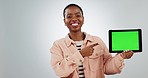 Green screen, tablet and face of black woman with hand pointing in studio agreement with app deal on grey background. Digital, space and portrait of African female model show sign up, news or service
