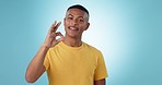 Black man, face and OK sign, promotion or success for agreement, smile and yes emoji on blue background. Feedback, portrait and opinion with vote, hand gesture and like decision for support in studio