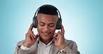 Headphones, move and young businessman in a studio listening to music, radio or album for entertainment. Smile, happy and professional male person streaming a song or playlist by blue background.