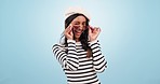 Fashion, sunglasses and woman wink in studio with trendy outfit, clothes and stylish accessories. Aesthetic, style and portrait of happy person with emoji, beauty and confidence on blue background