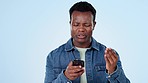 Black man in studio with phone and frustrated reading post, message or notification with connection glitch. Stress, anger and confused person with smartphone, error or spam email on blue background.