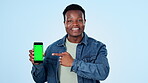 Man, face and phone green screen for marketing mockup, presentation or speaking of opportunity in studio. Young african person pointing to mobile app, sign up and tracking markers on blue background