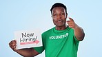 Volunteer, recruitment and face of black man with hand pointing at you in studio on blue background. Charity, donation and portrait of African male activist with ngo, poster or community service sign
