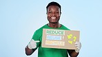 Recycle, sustainability and steps with a black man volunteer pointing to a poster on blue background in studio. Portrait, smile and climate change with happy young person showing a going green sign