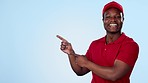 Happy delivery guy, space or pointing to offer, discount or distribution promotion on blue background. Face, black man or mockup for post service, sale choice or courier product placement in studio