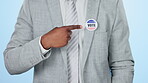 Hands, vote badge and man in politics, democracy and patriotism in studio isolated on a blue background. Election, pin and person pointing finger for choice of government, party or USA administration