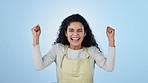 Woman, excited and face of success with fist in studio to celebrate deal, promotion and yes to winning lotto on blue background. Portrait of happy model, prize winner and cheers for bonus achievement