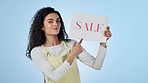 Retail, excited and a woman with a sale sign for marketing, store promo or welcome for a deal. Face portrait, gesture and an employee with a poster for shopping advertising on a blue background