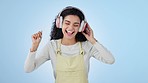 Dance, woman and headphones for music in studio to celebrate freedom, party and hearing audio on blue background. Happy model with energy listening to multimedia, disco sound and radio subscription 