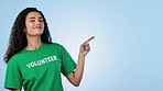 Volunteer, pointing and face of woman in studio for charity, donation and community service decision. Portrait of person with hand gesture for volunteering, NGO choice or support on blue background