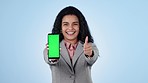 Business woman, phone green screen and thumbs up for marketing, social media like and presentation in studio. Face of employee with mobile app and slide for creative design space on a blue background