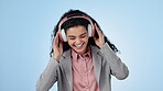 Music, headphones and business woman dance in studio isolated on a blue background. Excited professional moving to radio, audio and listening to sound for freedom, streaming song and media on tech