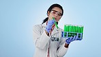 Science, research and sample with a woman on a blue background in studio for breakthrough innovation. Medicine, solution or test tube vial with a young scientist holding vaccine, cure or treatment