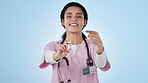 Doctor, point and vaccine for healthcare in studio in medical mockup on blue background. Female nurse, presentation and yes of glass vial of cure in pharmaceutical treatment for virus, disease or flu