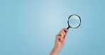 Blue background, hand and a magnifying glass for a search, investigation or looking. Analytics, zoom and detective tools for a crime, agent attention or discovery for evidence, spy or exploration