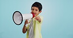 Communication, face or child with megaphone for news, opinion or sale announcement on blue background. Happy, pointing or young boy talking on loudspeaker for voice, speaking or attention in studio